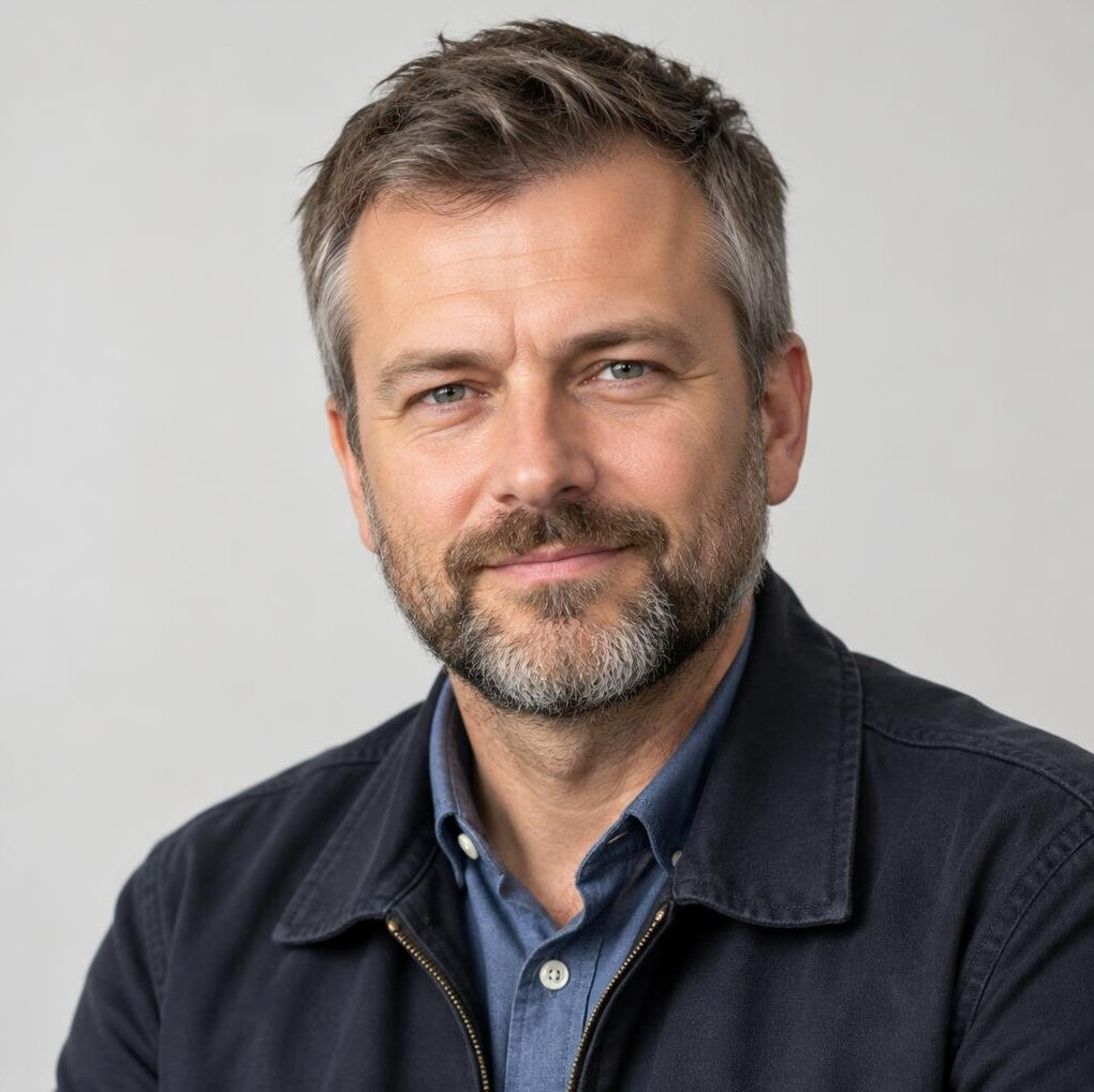 Professional portrait of a man with a short beard in a casual jacket