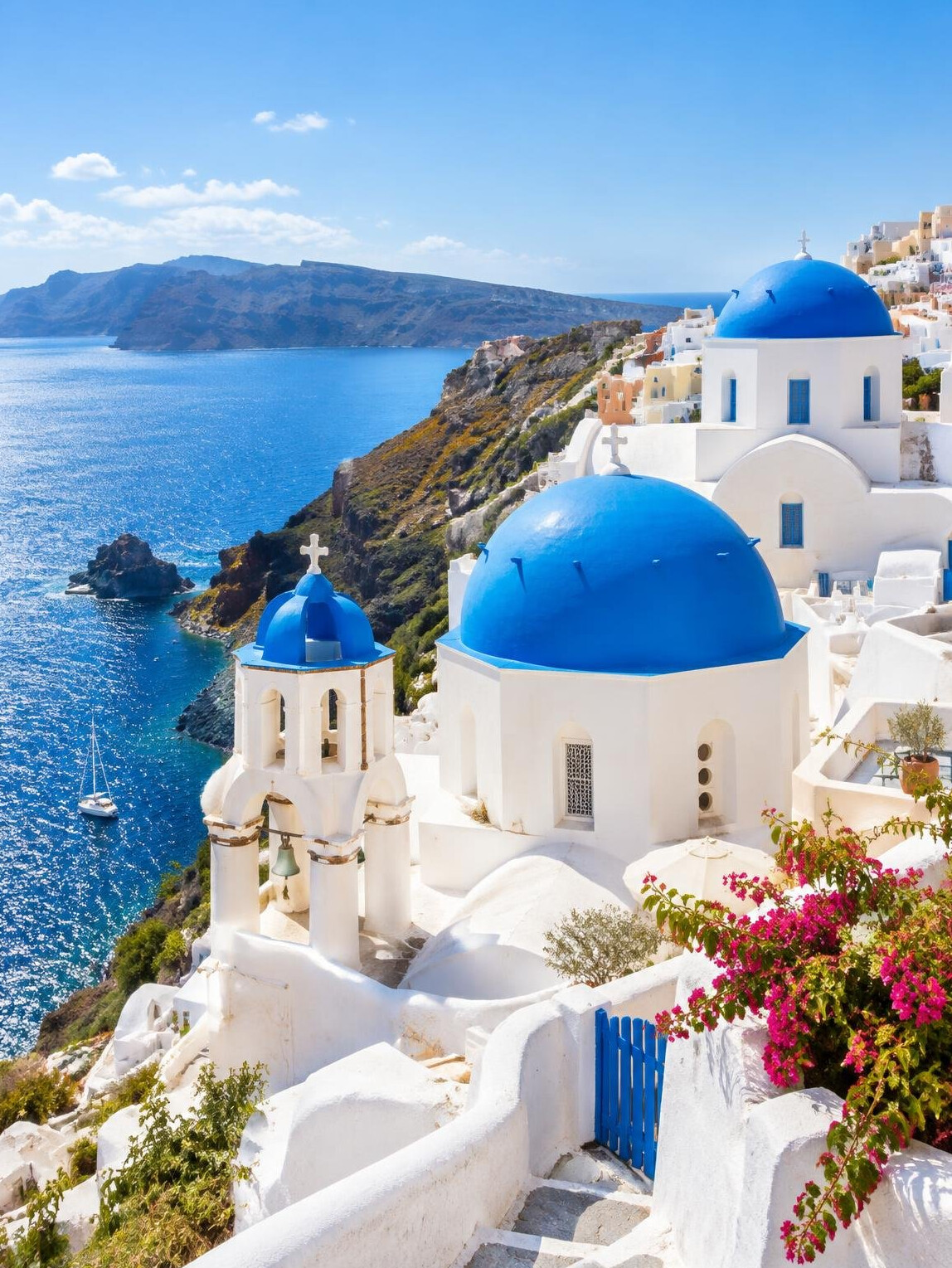 Whitewashed houses with blue domes above the Aegean Sea on a Greek island