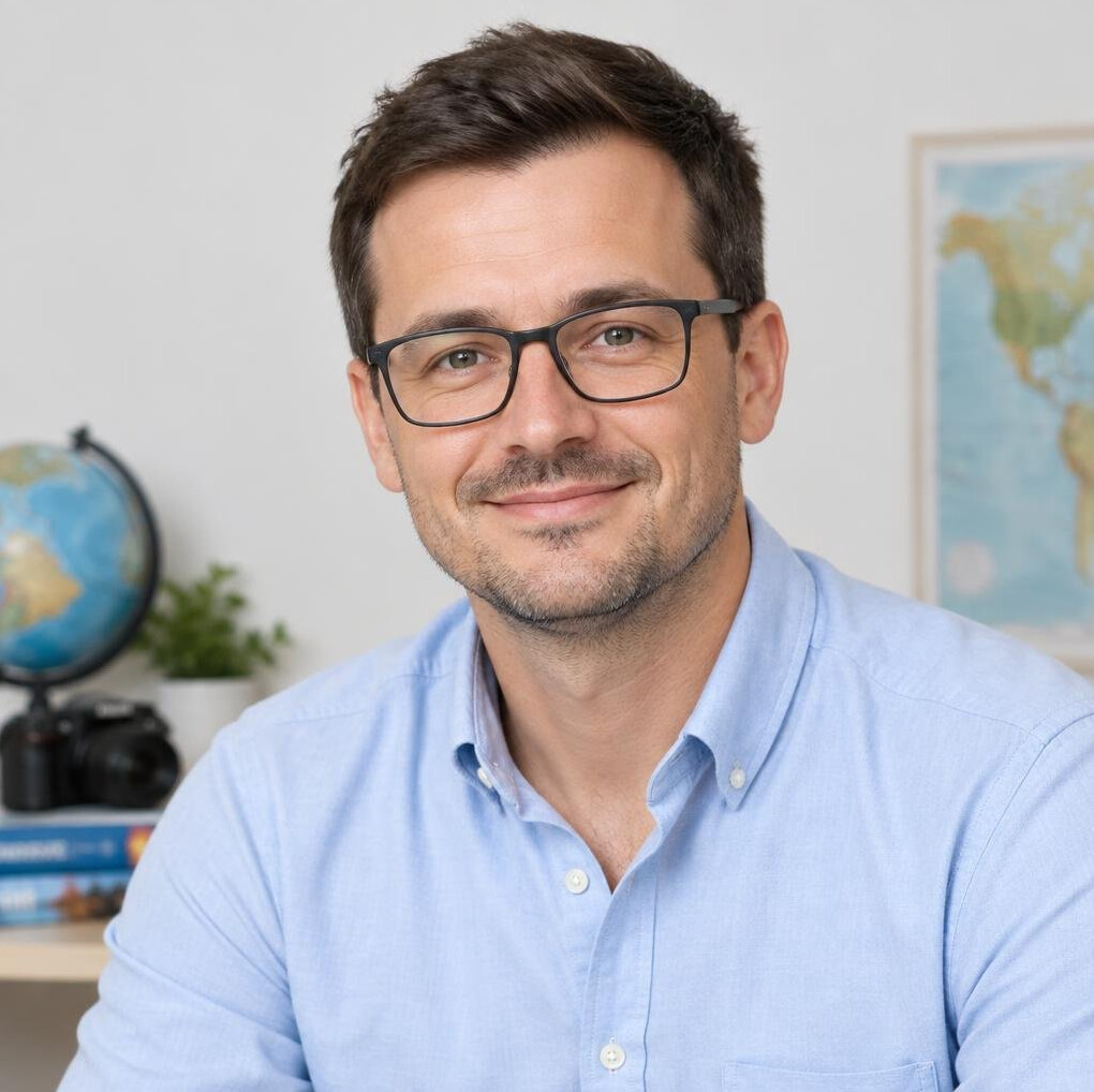 Professional portrait of a man with glasses and short dark hair